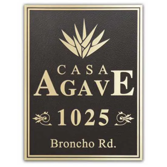 A custom bronze address plaque mounted to a stone wall.