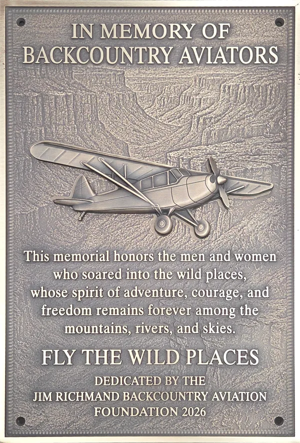 Bronze memorial plaque for backcountry aviators: a raised aircraft relief attached over an engraved canyon landscape, with engraved memorial wording below.