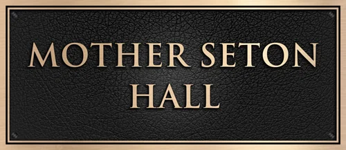 Bronze Mother Seton Hall room dedication name plaque with raised lettering on a leather-textured background.