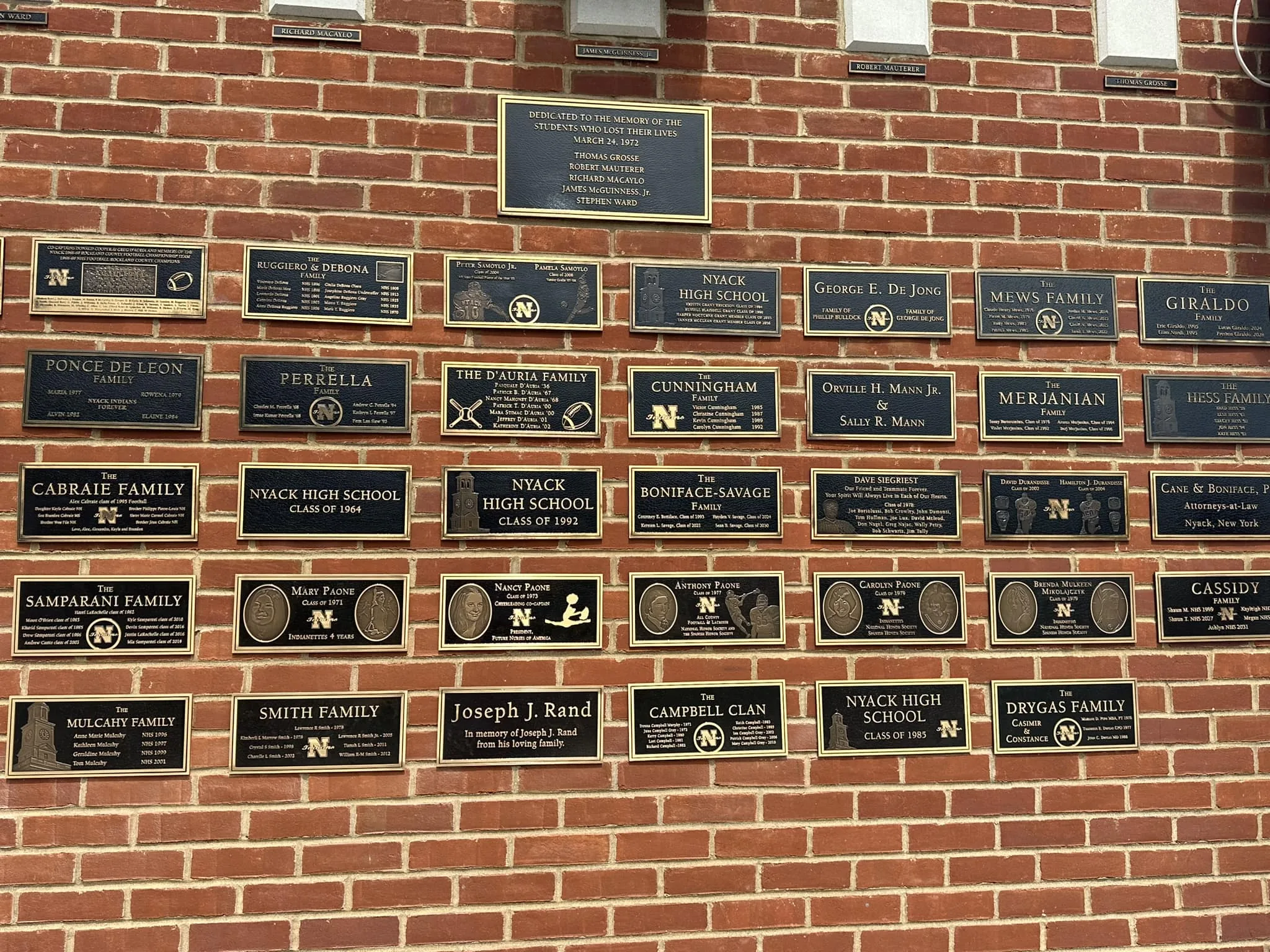 The Welcome to Nyack stadium entrance featuring the bronze sponsor wall and a dedication plaque.