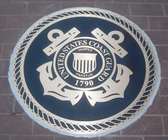 Bronze U.S. Coast Guard seal set flush into a brick floor